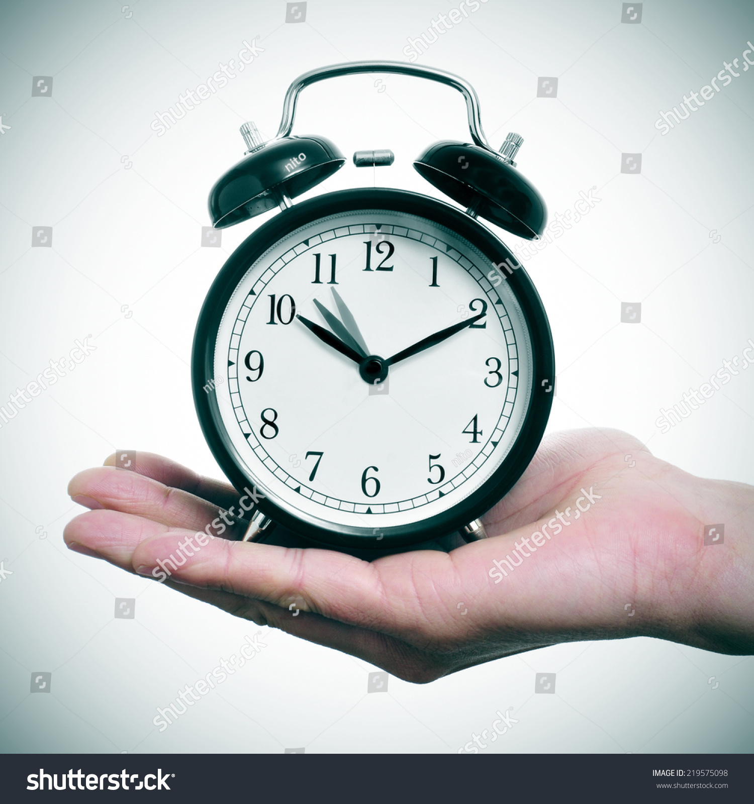 人拿着一个闹钟在一个小时后一个小时的时间调